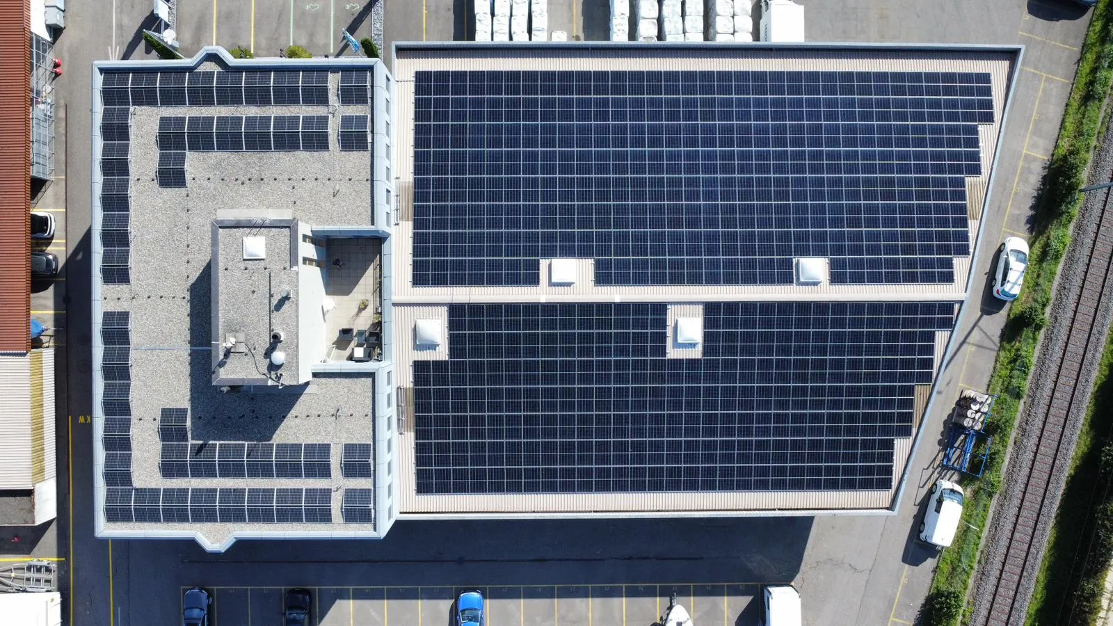Luftaufnahme eines Gewerbedachs, vollflächig mit Photovoltaikmodulen belegt